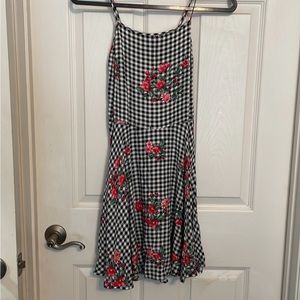 Tight fitting checker dress with red flower print. Adjustable straps size small.